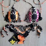 COSTUME DONNA EFFEK ESTATE 2025. TRIANGOLO CON IMBOTTITURA ESTRAIBILE E SLIP CON FIOCCO. FANTASIA BASE NERA CON SOLE TRIBALE