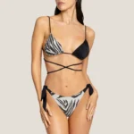 costume donna 4giveness della stagione estate 2025. Triangolo con imbottitura estribile e laccio lungo da legare intorno la vita. Bellissimi gli strass neri su una della coppa. Slip con fiocchi. Fantasia black & white