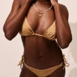 COSTUME DONNA MATINNE DELLA STAGIONE ESTATE 2025. TRIANGOLO CON IMBOTTITTURA ESTRAIBILE, SLIP LACCETTI CON STRASS APPLICATI. COLOR PAMPAS