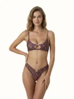 COSTUME DONNA ME FUI DELLA STAGIONE ESTATE 2026. TOP CON IMBOTTITURA ESTRAIBILE, FESSURA CENTRALE E BELLISSIMO DETTAGLIO IN METALLO CHE RITROVIAMO ANCHE SULLA BRASILIANA. COLORE VIOLA CON FIORELLINI