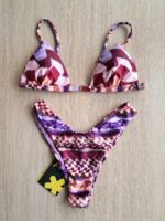 COSTUME DONNA EFFEK A DUE PEZZI DELLA COLLEZIONE ESTATE 2026. TRIANGOLO CON IMBOTTITUTA ESTRAIBILE E DETTAGLIO IN METALLO TRA LE COPPE. FANTASIA NEI TONO DEL LILLA, ROSA E BORDEAUX