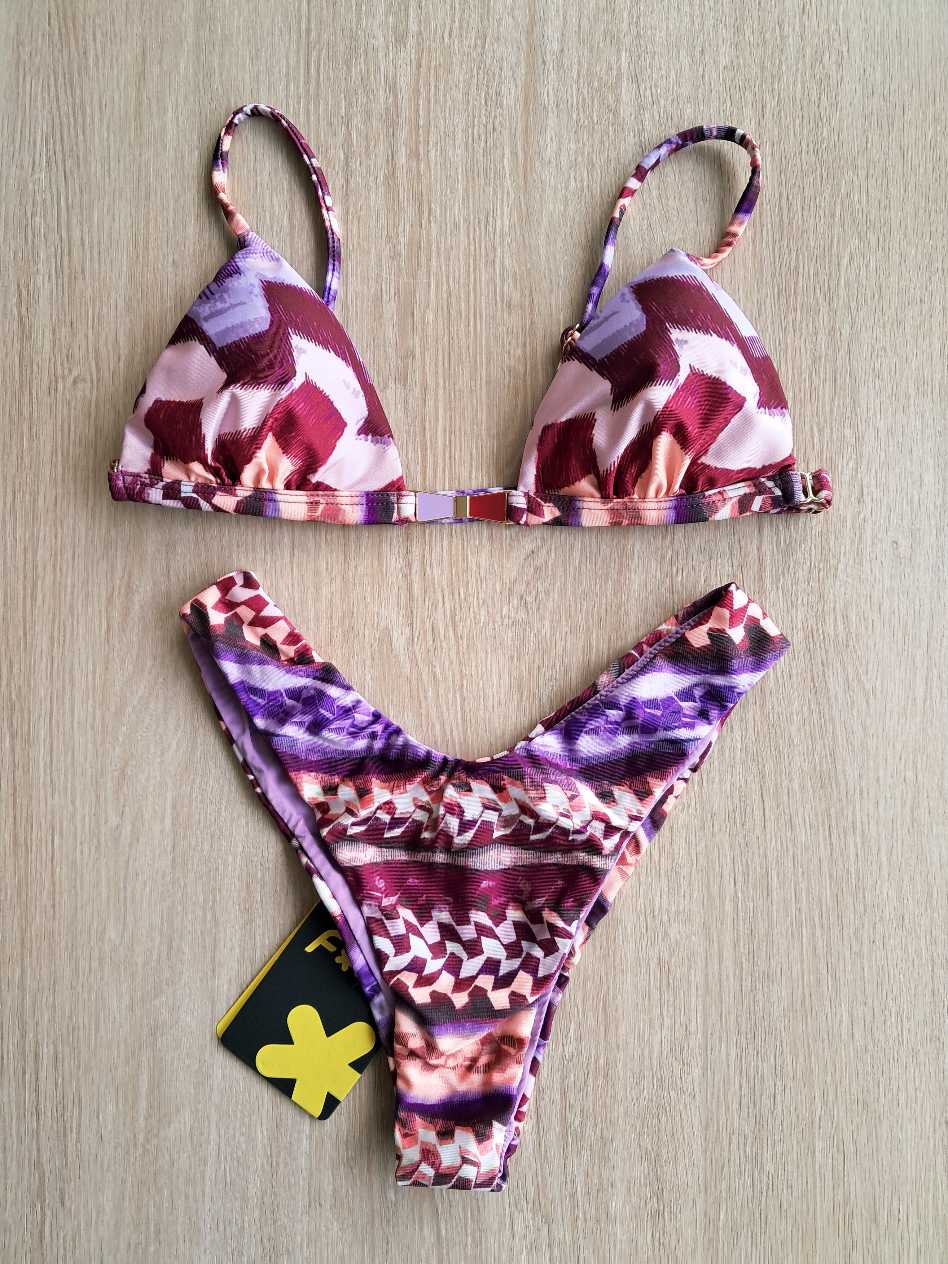 COSTUME DONNA EFFEK A DUE PEZZI DELLA COLLEZIONE ESTATE 2026. TRIANGOLO CON IMBOTTITUTA ESTRAIBILE E DETTAGLIO IN METALLO TRA LE COPPE. FANTASIA NEI TONO DEL LILLA, ROSA E BORDEAUX COSTUME DONNA EFFEK A DUE PEZZI DELLA COLLEZIONE ESTATE 2026. TRIANGOLO CON IMBOTTITUTA ESTRAIBILE E DETTAGLIO IN METALLO TRA LE COPPE. FANTASIA NEI TONO DEL LILLA, ROSA E BORDEAUX