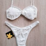 COSTUME DONNA EFFEK A DUE PEZZI DELLA STAGIONE ESTATE 2025. TOP/FASCIA CON IMBOTTITURA ESTRAIBILE, CHIUSURA CON GANCIO E BRETELLINA REGOLABILE. TESSUTO IN SANGALLO BIANCO