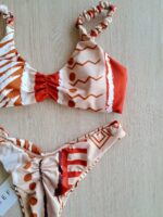 COSTUME DONNA ME FUI DELLA COLLEZIONE ESTATE 2026. COSTUME A DUE PEZZI A TOP CON IMBOTTITURA ESTRAIBILE, BRETELLINA ARRICCIATA E CHIUSURA CON GANCIO. FANTASIA SU BASE BEIGE