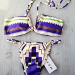 COSTUME DONNA ME FUI A DUE PEZZI DELLA STAGIONE ESTATE 2026. FASCIA CON IMBOTTITURA ESTRAIBILE E DETTAGLIO. BRASILIANA REGOLABILE LATERALMENTE. BASE PANNA CON FANTASIA VIOLA, VERDE E MARRONE