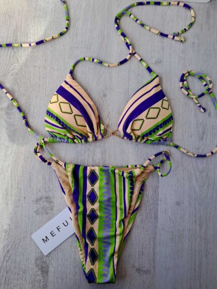 COSTUME DONNA ME FUI A DUE PEZZI DELLA STAGIONE ESTATE 2026. TRIANGOLO CON IMBOTTITURA ESTRAIBILE E DETTAGLIO IN METALLO COLOR ORO TRA LE COPPE. BASE PANNA CON FANTASIA VERDE E VIOLA