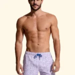 COSTUME UOMO EFFEK DELLA STAGIONE ESTATE 2026. PANTALONCINO BASE BIANCA CON MICROFANTASIA DI FIORELLINI LILLA