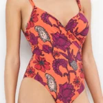 COSTUME DONNA GISELA INTERO DELLA COLLEZIONE ESTATE 2026. CON FERRETTO ED IMBOTTITURA ED INCROCIO SULLE COPPE. BASE COLOR CORALLO CON FANTASIA FIORI VIOLA